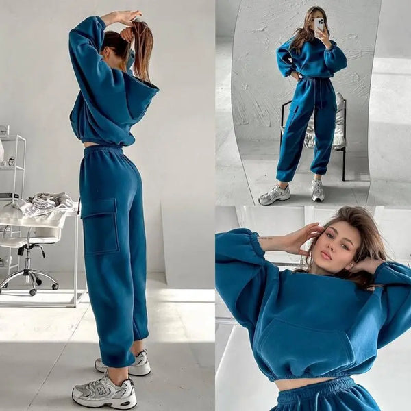 Vrouw in blauwe joggingpak, comfortabele loungewear, sportieve outfit, casual mode, trendy dameskleding, thuisoutfit, moderne stijl.