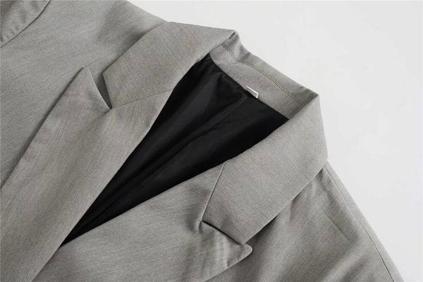 Grijze blazer met zwarte voering, close-up van de kraag en schouder, moderne zakelijke kleding, stijlvolle herenmode, hoogwaardige stof.