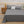 Grijs beddengoed set op tweepersoonsbed met kussen, houten nachtkastje met zonnebloemen, modern slaapkamerinterieur, comfortabel en stijlvol.