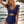 Vrouw in blauwe badpak met ruches, strand op achtergrond, zomermode, strandkleding, stijlvolle badmode, zonsondergang, zeezicht.