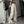 Vrouw in trendy streetwear met wijde beige cargo broek, zwart crop top en sneakers, poseert voor spiegel. Urban mode, casual stijl, jongerentrend.