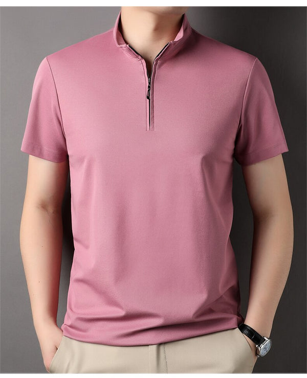 Man in roze polo met rits, korte mouwen, casual stijl, tegen grijze achtergrond. Perfect voor zomermode en herenoutfits.