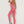 Vrouw in roze sportlegging en top, poseert tegen witte achtergrond. Fitnessmode, sportkleding, actieve levensstijl, trendy workout outfit.