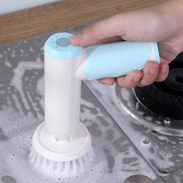 Elektrische schrobborstel met blauwe handgreep, gebruikt voor het reinigen van een fornuis. Ideaal voor keukenreiniging en hardnekkig vuil verwijderen.