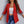 Rode damesblazer met opgerolde mouwen, gedragen over een witte crop top en blauwe jeans. Modieuze outfit voor casual en zakelijke gelegenheden.