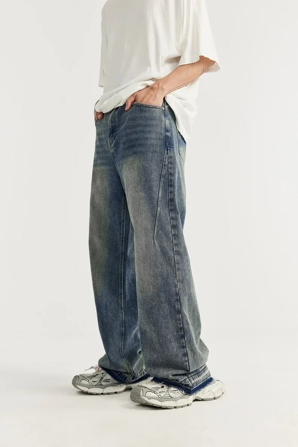 Man in oversized jeans en witte sneakers, casual mode, witte achtergrond. Trendy streetwear, comfortabele stijl, moderne kleding.