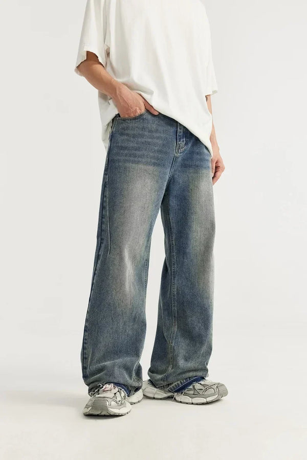 Wijd uitlopende jeans voor heren, gedragen met witte sneakers en een wit T-shirt. Trendy casual mode, comfortabele pasvorm, streetwear stijl.