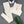 Crèmekleurige ribgebreide sportset met legging en crop top, naast witte koptelefoon en groene palmbladaccessoire op grijze achtergrond.