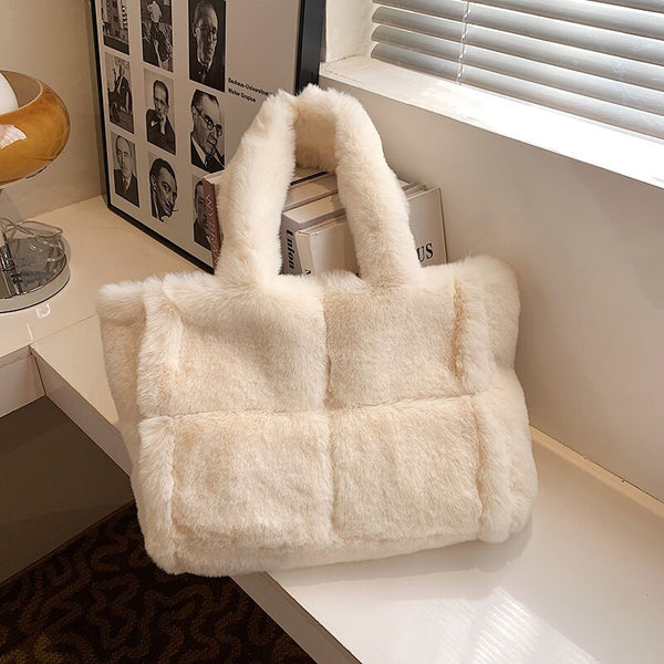 Witte pluchen handtas op tafel, moderne stijlvolle tas, zachte faux bont textuur, trendy accessoire voor dames, perfect voor wintermode.
