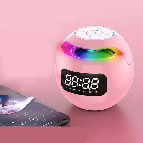 Roze Bluetooth-luidspreker met LED-verlichting en digitale klok, naast smartphone. Draadloze muziekspeler, modern design, ideaal voor thuisgebruik.