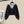 Zwarte cropped cardigan met knopen en grijze capuchon, hangend aan een hanger. Modieuze dameskleding, ideaal voor casual herfstoutfits.