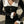Vrouw in zwarte geribbelde jurk met witte kraag en knopen, houdt zwarte handtas vast. Elegante mode, herfstkleding, straatstijl.