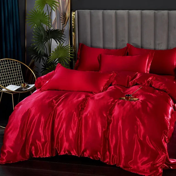 Rode satijnen dekbedovertrekset op een luxe bed met grijze hoofdeinde, omgeven door gouden accenten en groene planten. Perfect voor slaapkamerinrichting.
