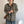 Vrouw draagt zwart-wit gestreepte hoodie met capuchon, bruine schoudertas en blauwe jeans. Modieuze casual outfit voor dames.