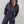 Vrouw in zwarte hoodie jumpsuit met capuchon, ritssluitingen en elastische taille. Modieuze streetwear outfit voor dames.