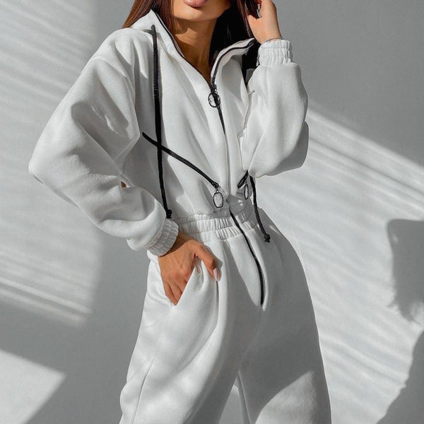 Vrouw in witte fleece jumpsuit met zwarte ritsen en trekkoorden, modieuze sportieve outfit, casual winterkleding, minimalistisch design.