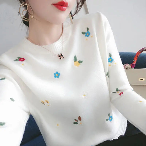 Witte trui met kleurrijke bloemenprint, gedragen door vrouw. Modieuze dameskleding, trendy gebreide sweater, casual stijl, herfstmode.