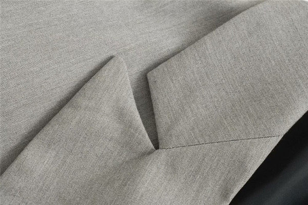 Grijze stoffen textuur met scherpe vouwen, close-up van een moderne, minimalistische stof. Geschikt voor mode, interieur en design inspiratie.