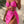 Vrouw in roze bikini met hartvormige details, omgeven door tropische bladeren. Zomerse strandmode, trendy badkleding, stijlvolle strandoutfit.