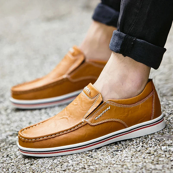 Bruine leren loafers voor heren, casual en comfortabel, met witte rubberen zool en stikseldetails. Perfect voor dagelijks gebruik en modebewuste mannen.