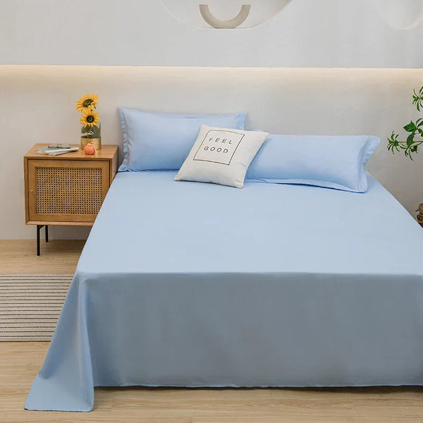 Lichtblauw beddengoed set op tweepersoonsbed met kussen "Feel Good", houten nachtkastje met zonnebloemen, moderne slaapkamer inrichting.