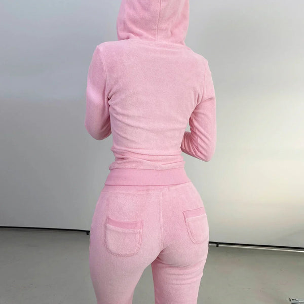 Roze dames trainingspak met capuchon, achterkant. Comfortabel fleece materiaal, perfect voor casual en sportieve outfits. Trendy en stijlvol design.