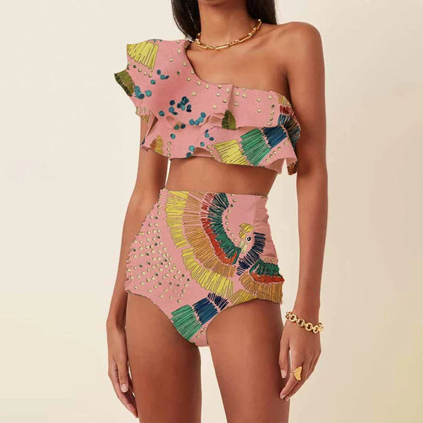 Vrouw in roze asymmetrische bikini met kleurrijke patronen en ruches, modieuze strandkleding, zomertrends, hoge taille, sieradenaccessoires.