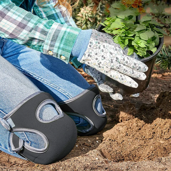 Tuinier met kniebeschermers en handschoenen plant groene zaailing in pot. Tuinaccessoires, plantenverzorging, buiten tuinieren.