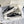 Zwarte canvas sneakers met witte veters en decoratieve stiksels in een schoenendoos. Trendy platformzolen, casual stijl, unisex ontwerp.