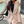 Vrouw in beige blazer bij fontein, draagt zonnebril en zwarte tas. Stijlvolle mode, stedelijke achtergrond, trendy outfit, casual chic look.