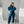 Vrouw in blauwe joggingpak en witte sneakers maakt selfie in spiegel. Moderne casual mode, comfortabele loungewear, minimalistisch interieur.