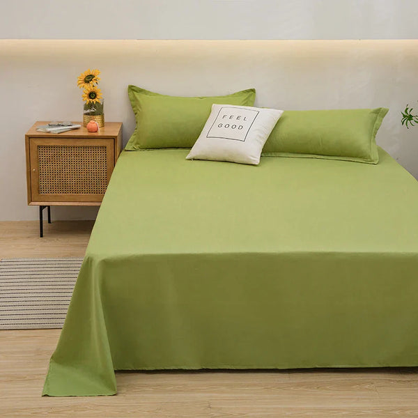 Groen beddengoed op tweepersoonsbed met kussen "Feel Good", naast houten nachtkastje met zonnebloemen, in moderne slaapkamer.