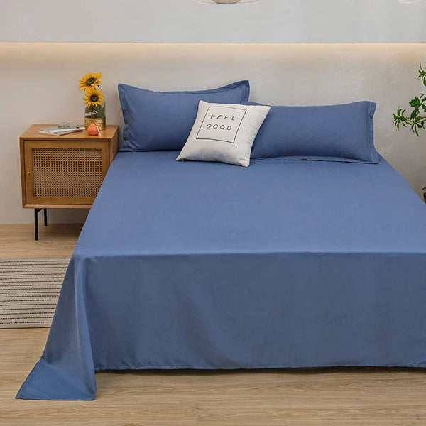 Blauw katoenen beddengoed set op tweepersoonsbed met kussen "Feel Good", houten nachtkastje met zonnebloemen, moderne slaapkamer inrichting.