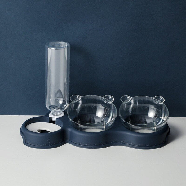 Kattenvoerbak met waterdispenser, dubbele transparante kommen en een automatische waterfles op een donkerblauwe basis, ideaal voor huisdieren.