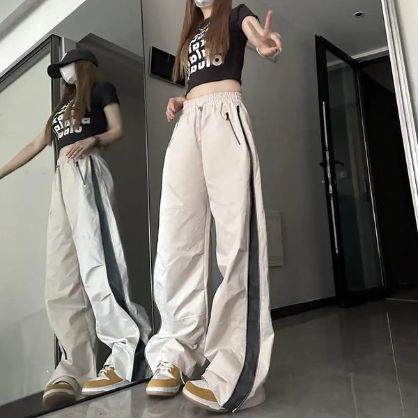 Vrouw in casual outfit met wijde beige broek en zwart T-shirt poseert voor spiegel. Trendy streetwear, comfortabele mode, moderne stijl.