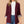 Vrouw in bordeaux blazer met opgerolde mouwen, witte coltrui en blauwe jeans. Modieuze dameskleding, casual chic stijl.