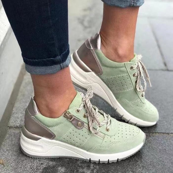 Mintgroene dames sneakers met witte zool en metallic details, gedragen op straat. Modieuze casual schoenen, perfect voor dagelijks gebruik.