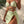 Vrouw in lichtgroene bikini met hartvormige uitsnijdingen, omgeven door tropische bladeren. Zomerse strandmode, trendy badkleding.