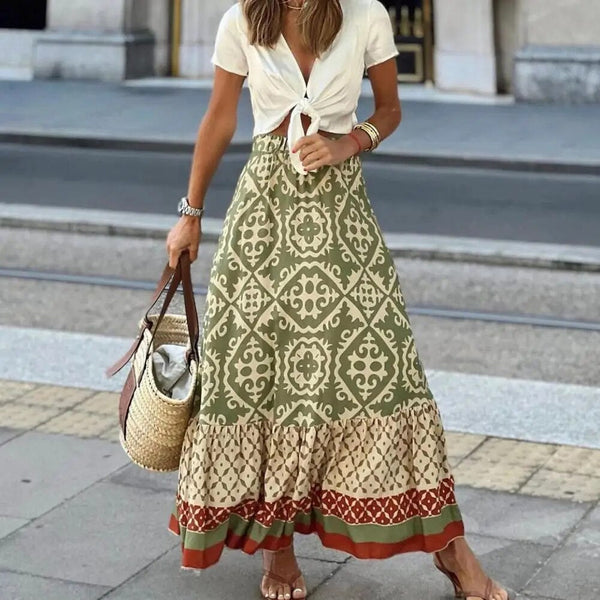 Vrouw in bohemian maxi-rok met etnisch patroon, witte knoopblouse en rieten tas. Zomerse mode op straat, trendy boho-chic stijl.