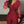 Vrouw in elegante rode jumpsuit met glinsterende details en transparante mouwen, modieuze avondkleding, stijlvolle outfit voor speciale gelegenheden.