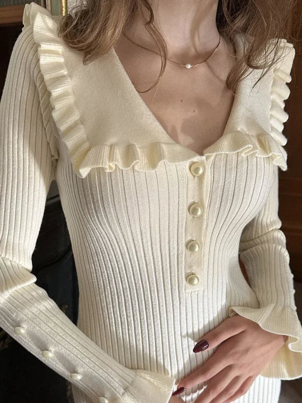 Vrouw in crèmekleurige geribbelde trui met knopen en ruches, elegante herfstmode, stijlvolle dameskleding, modieuze outfit voor koel weer.