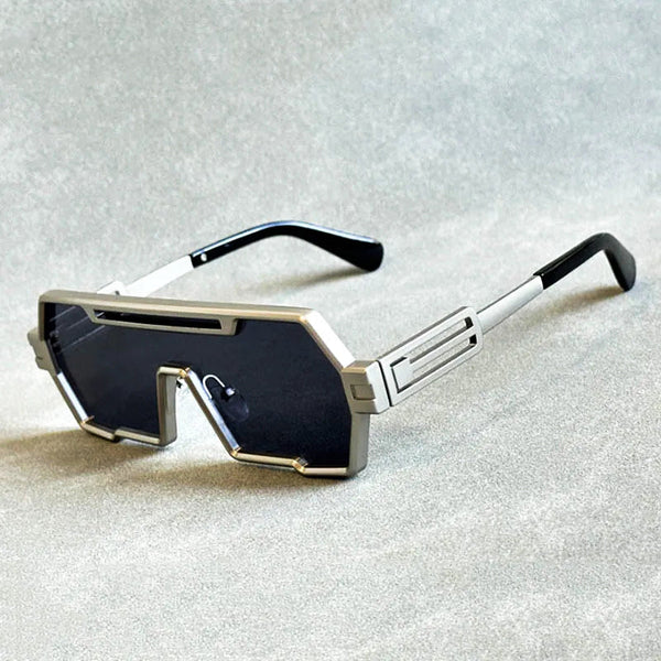 Zilveren futuristische zonnebril met rechthoekige glazen en zwarte pootjes op grijze achtergrond. Trendy unisex accessoire, UV-bescherming.