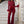 Vrouw in elegante rode jumpsuit met pailletten en veren, poseert op marmeren trap. Modieuze avondkleding, glamour, stijlvolle outfit.