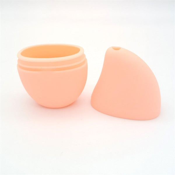 Ronde, perzik-kleurige siliconen opbergdoos met deksel, ideaal voor cosmetica of sieraden. Compact en stijlvol design voor dagelijks gebruik.