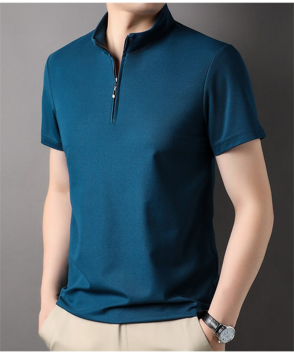 Man in blauwe polo met ritssluiting, korte mouwen, beige broek en horloge. Stijlvolle herenkleding, casual mode, moderne outfit.