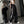 Vrouw in trendy zwarte wijde broek met witte strepen, crop top en sneakers, poseert voor spiegel. Streetwear mode, casual outfit, urban stijl.