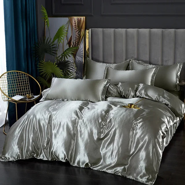 Luxe zilverkleurig satijnen dekbedovertrek op kingsize bed met kussens, gouden decoratie en groene planten, moderne slaapkamerinrichting.