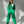 Vrouw in groene jumpsuit poseert in zonlicht. Modieuze dameskleding, comfortabele outfit, trendy streetwear, casual stijl, groene mode.