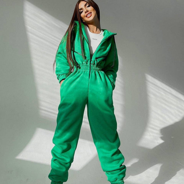 Vrouw in groene jumpsuit poseert in zonlicht. Modieuze dameskleding, comfortabele outfit, trendy streetwear, casual stijl, groene mode.
