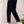 Man in donkerblauwe broek en witte sneakers, zijaanzicht. Stijlvolle casual mode, comfortabele herenkleding, moderne schoenen.